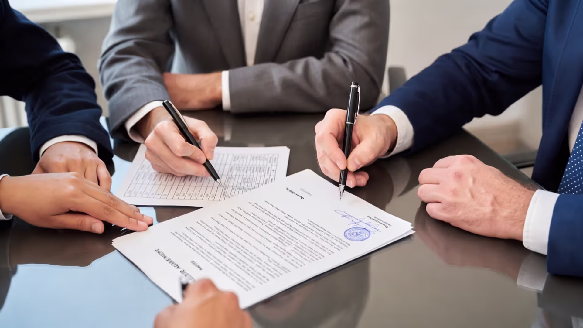 Co-founders signing a shareholder agreement next to an ownership percentage sheet